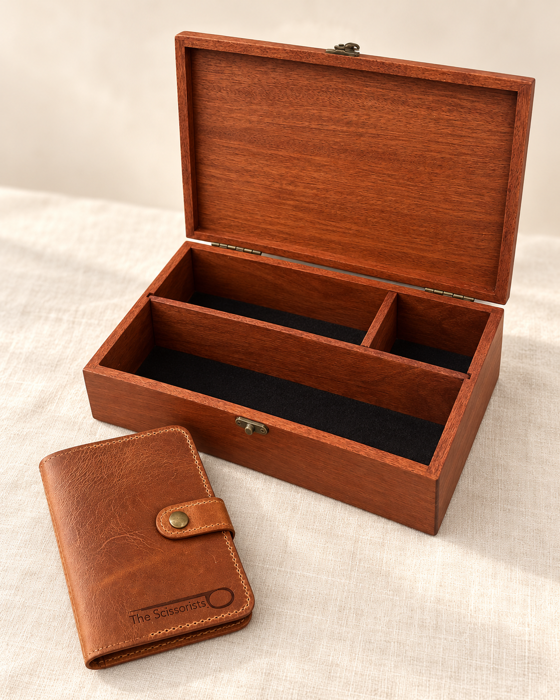 Open Large Studio Box showing its felt-lined compartments beside a closed tan leather Stitcher's Wallet, on ivory linen.