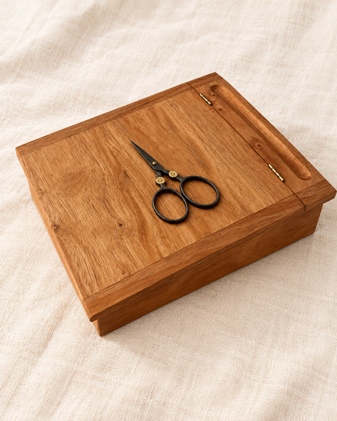 Mahogany Stitcher's Lap Desk with Moon Flower scissors resting on its sloped lid, on ivory linen.